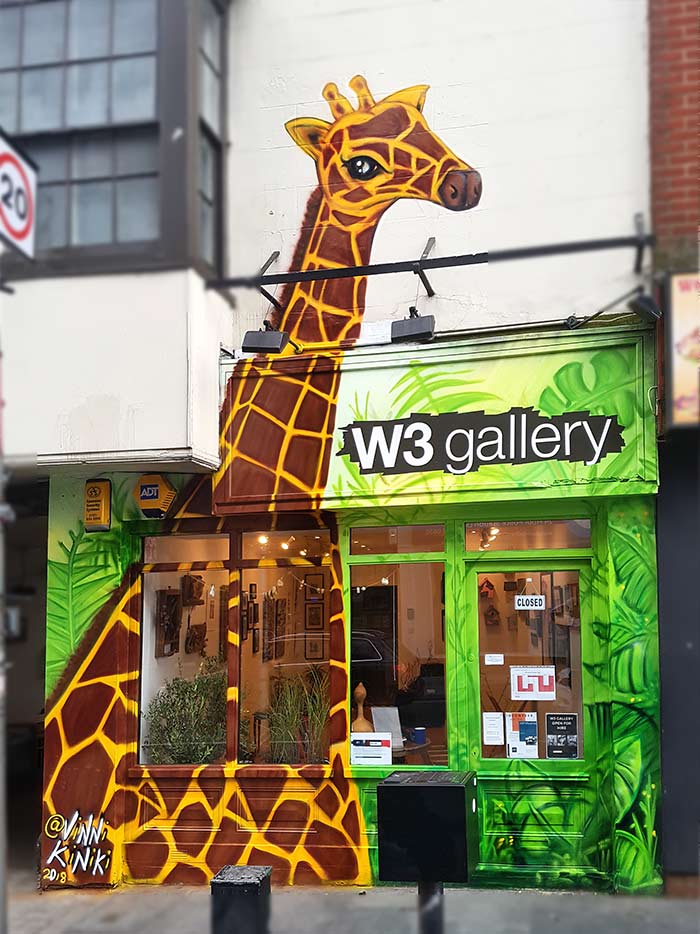 giraffe in the jungle street art mural on gallery facade