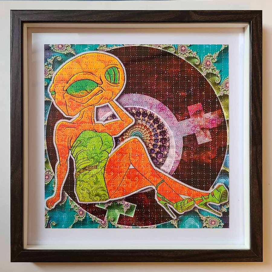 photo of a framed lsd blotter art gift featuring fractal psychedelic design of female alien in a green dress wearing high heels