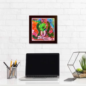photo of a framed lsd blotter acid art print next to a desk with a laptop and office equipment