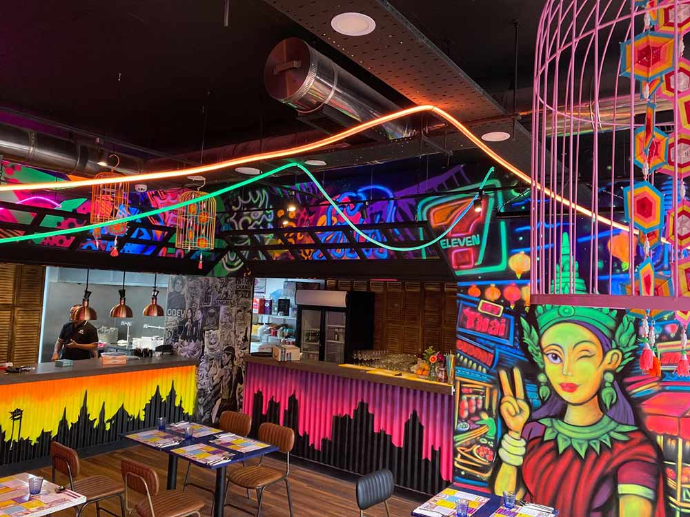 Manchester Piccadilly restaurant interior featuring street art and black light murals
