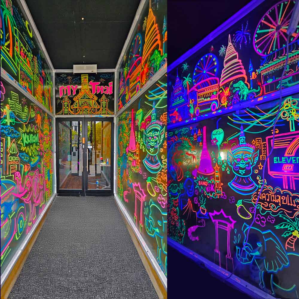 UV reactive black light mural painted on glass entrance of My Thai restaurant in Manchester Piccadilly, featuring vibrant street-style designs by artist ViNNi KiNiKi