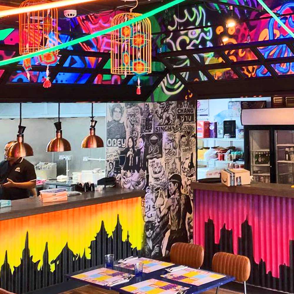 Street poster art column at My Thai restaurant in Manchester Piccadilly, designed by artist ViNNi KiNiKi layered fly posters inspired by JR, Shepard Fairey, Banksy, and D*Face