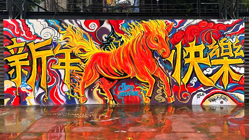 Black light graffiti mural of the Fire Horse in daylight at Taipei Cinema Park, Ximending, Taiwan, painted with fluorescent spray paint for Chinese New Year 2026.